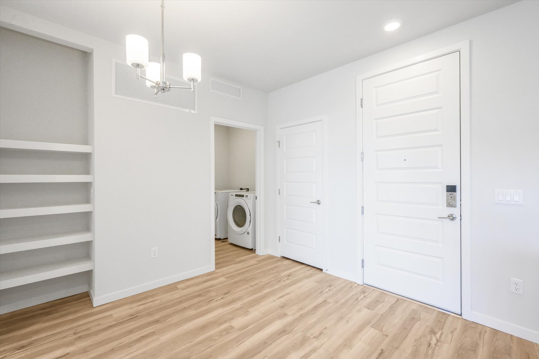 A room with white cabinets and a washer and dryer.