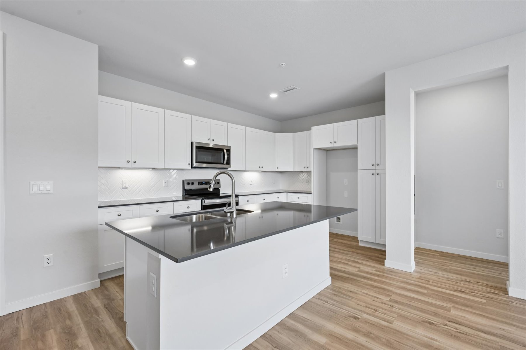 A kitchen with white cabinets.