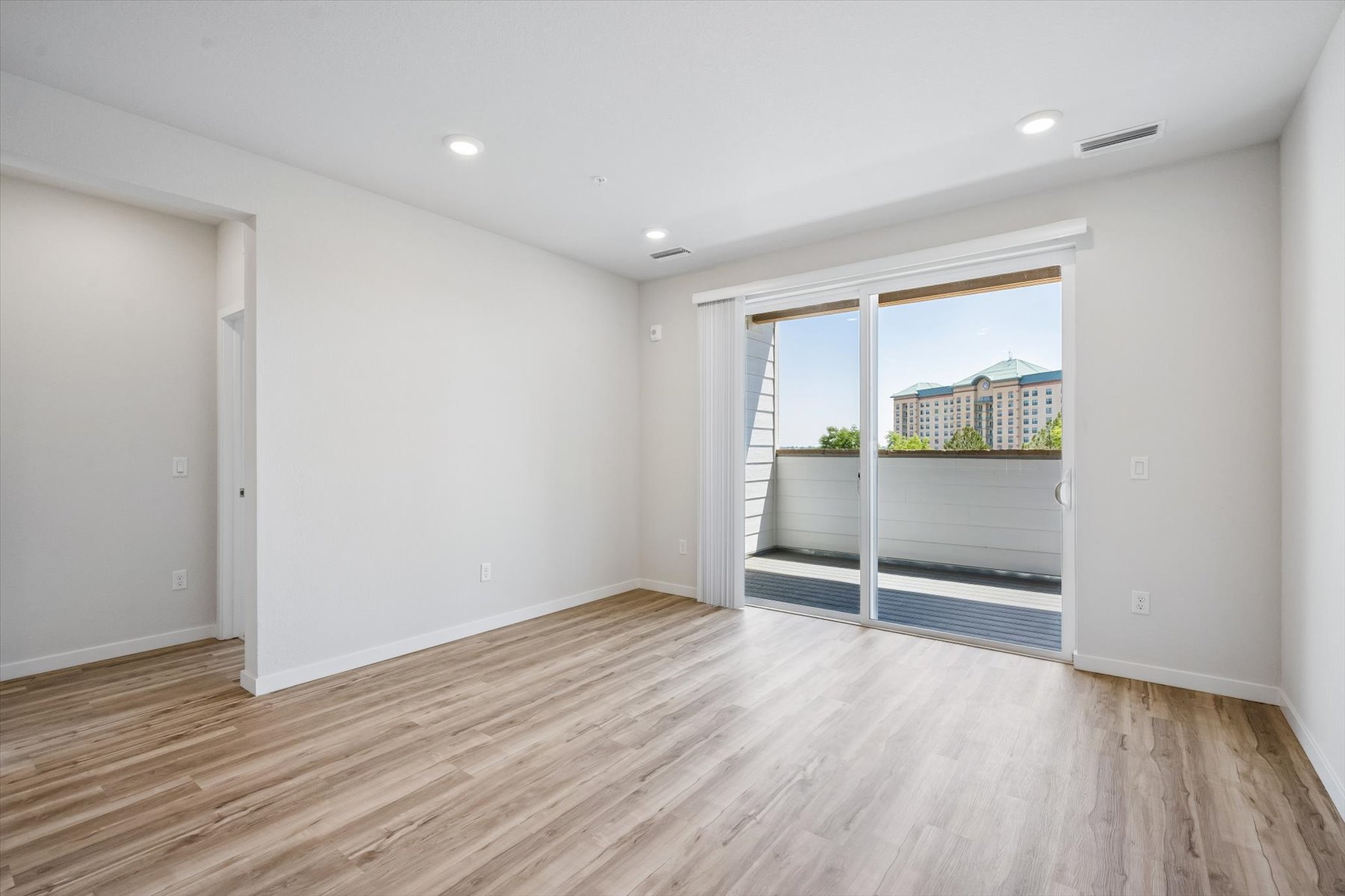 A room with a wood floor and a wood floor with a window.