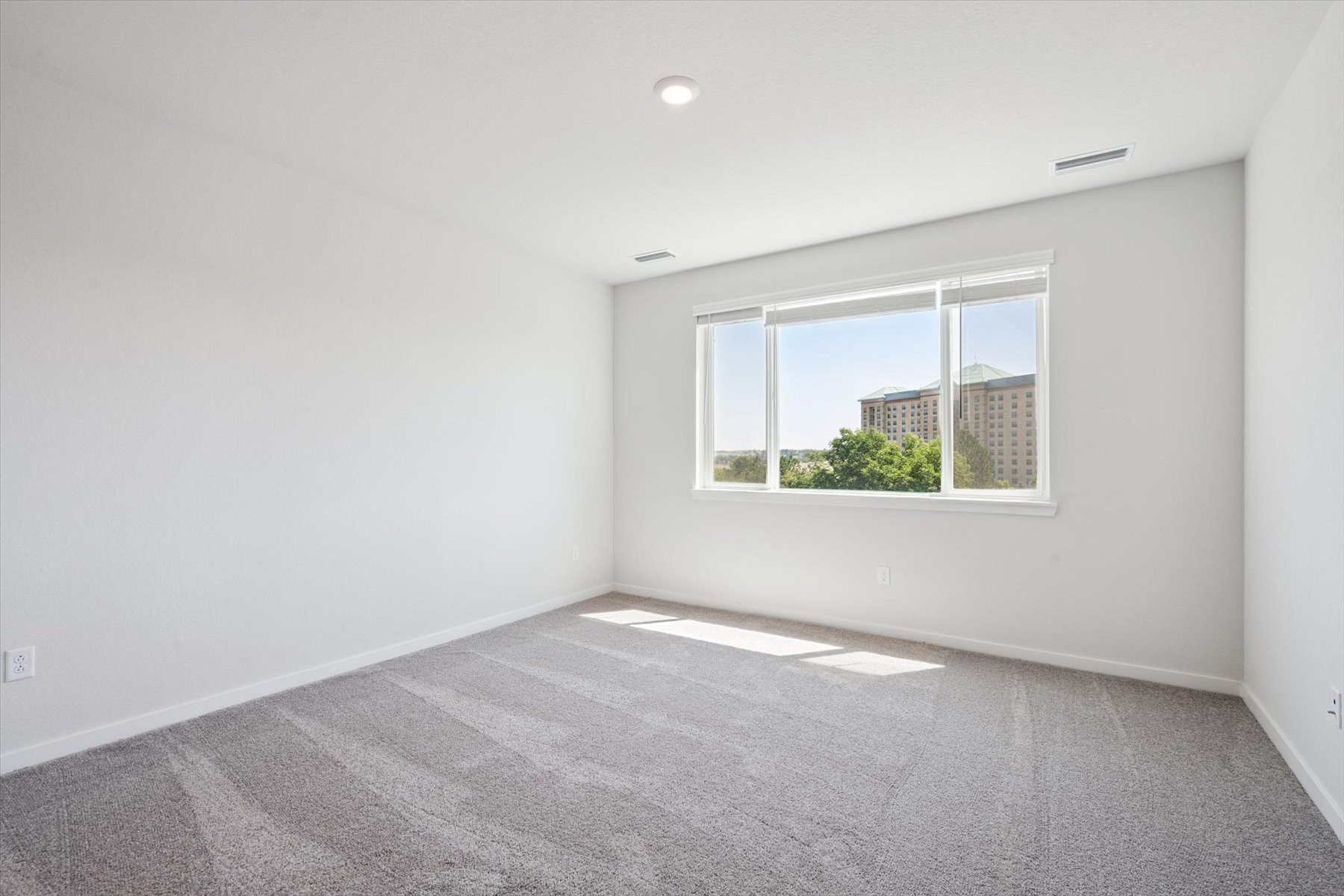 A room with a window and a carpet.