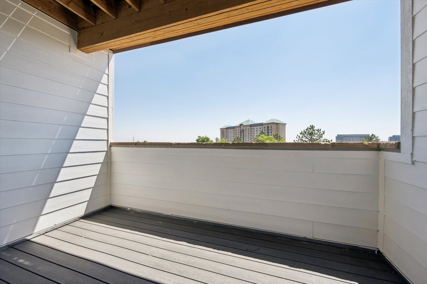 A white wall with a building in the background.