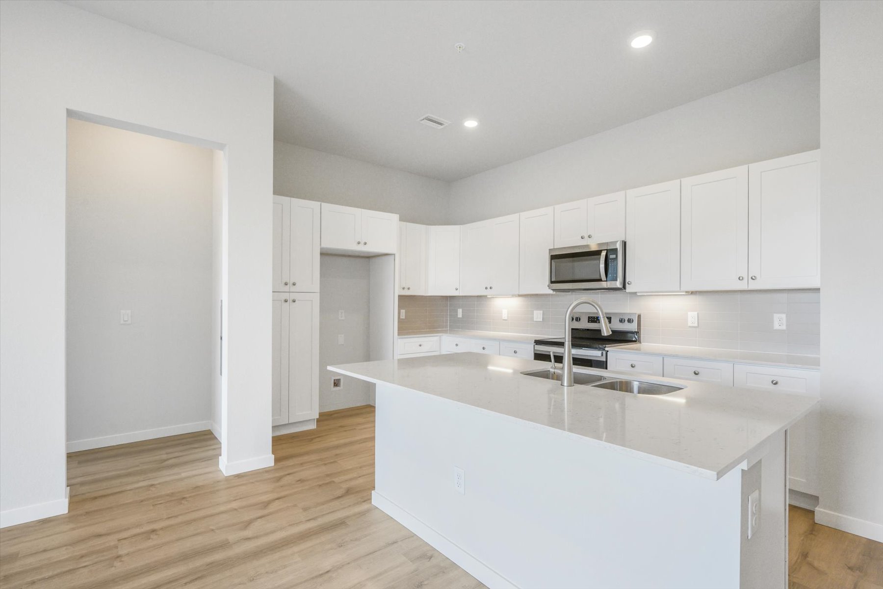 A kitchen with white cabinets.