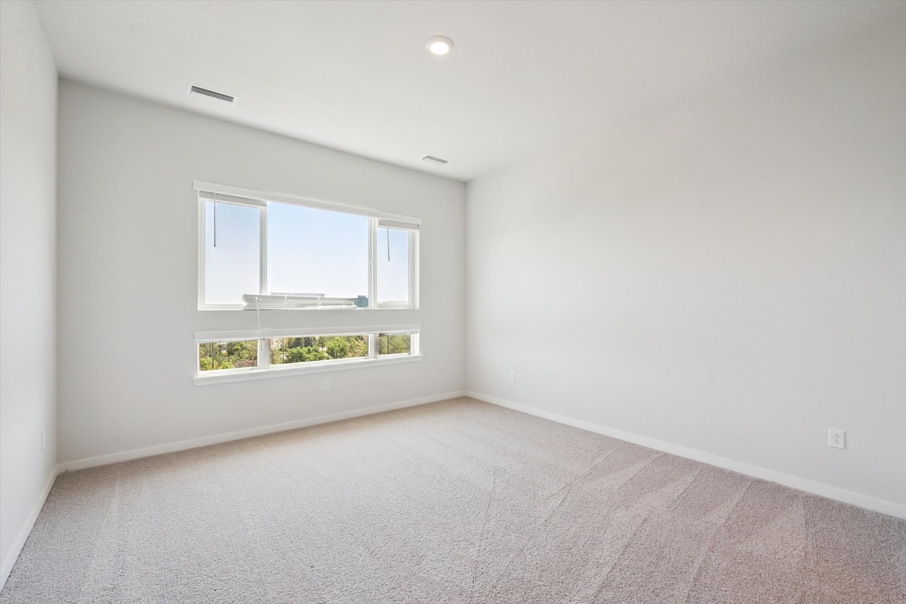 A room with a window and a carpet.