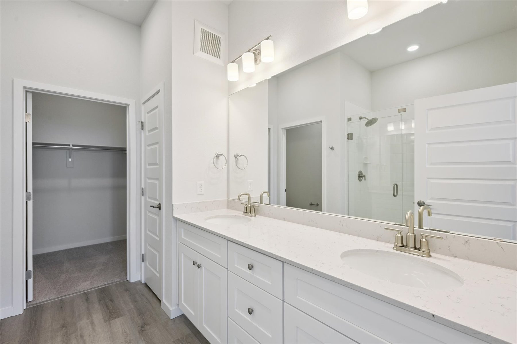 A bathroom with white cabinets.
