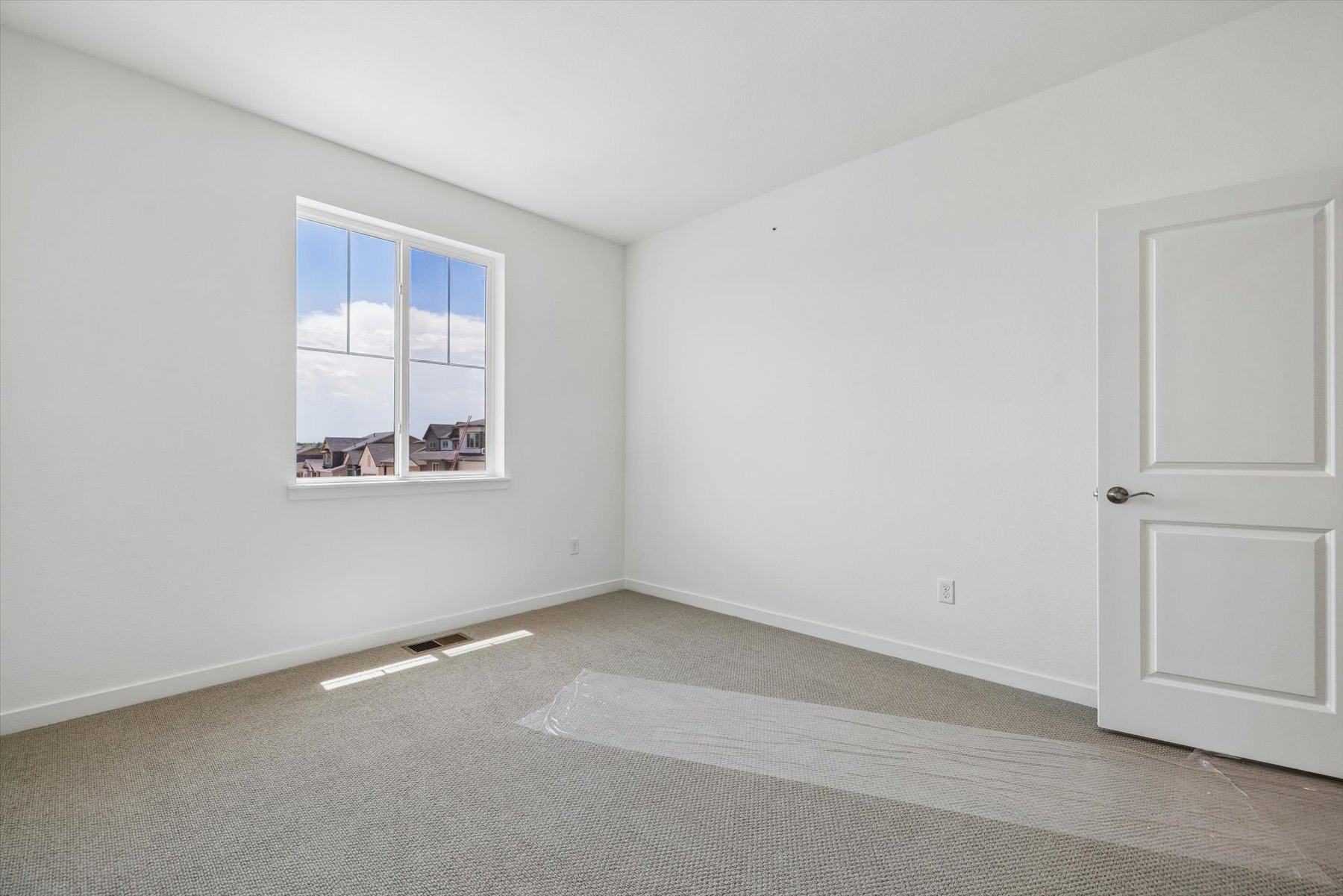 A room with a window and a carpet.