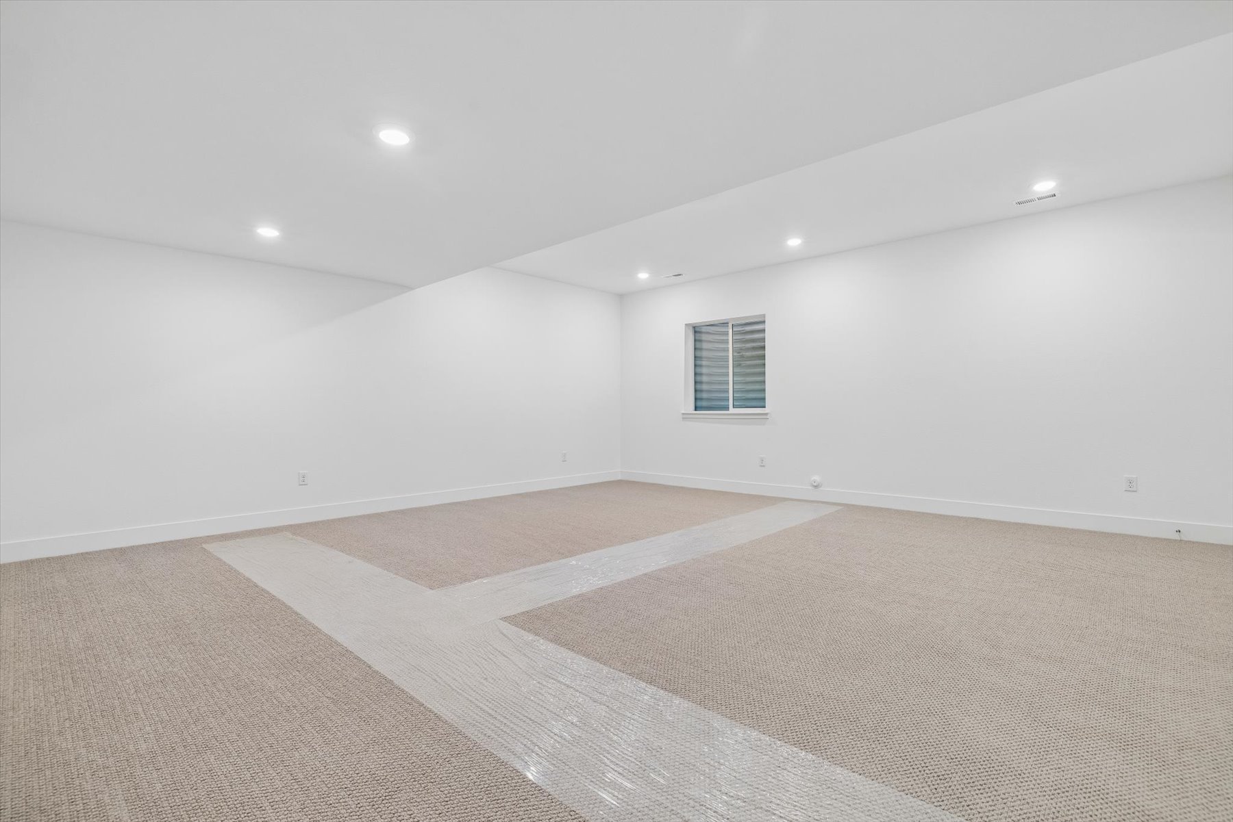A room with a carpet and a rug.