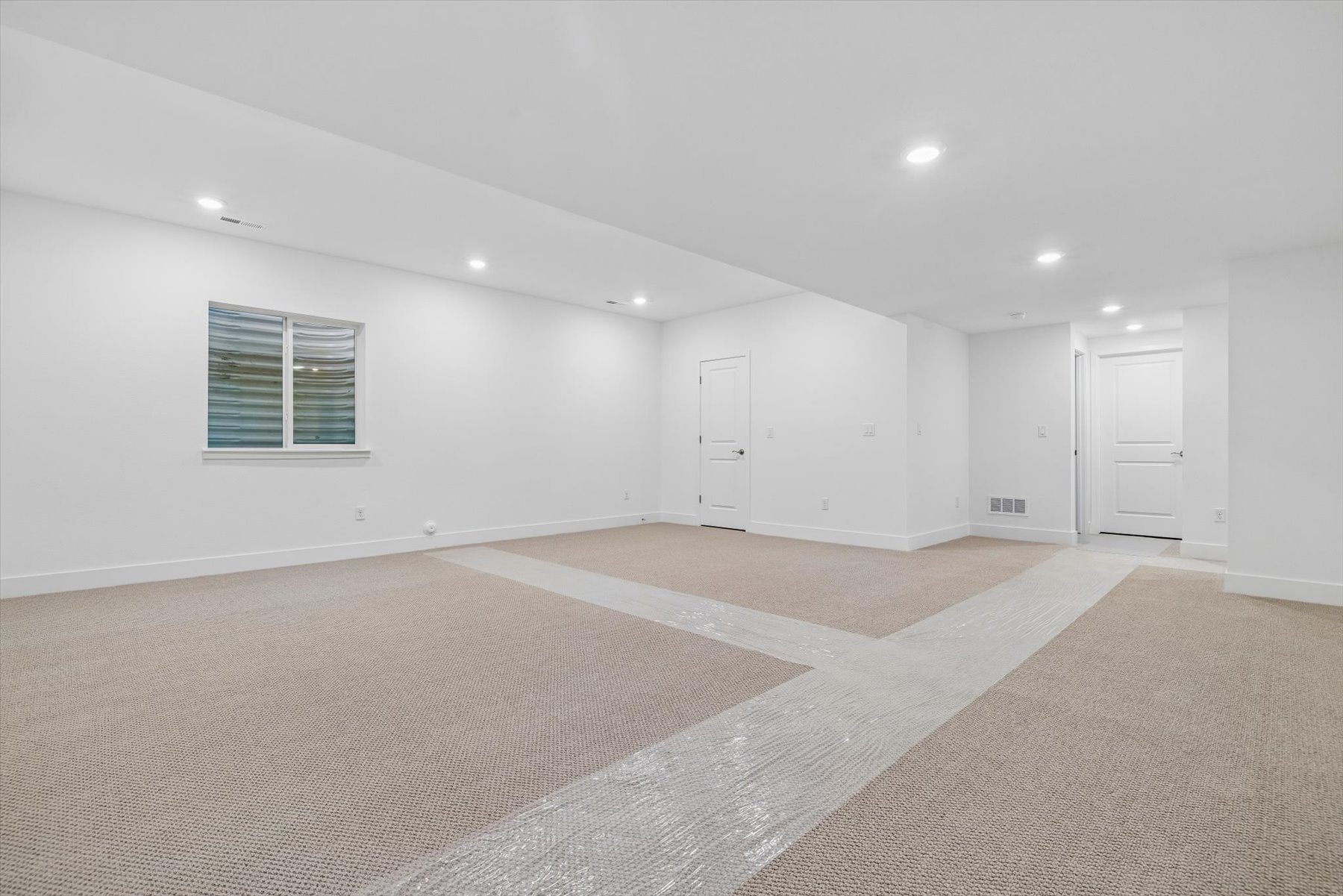 A room with white walls and a carpeted floor.
