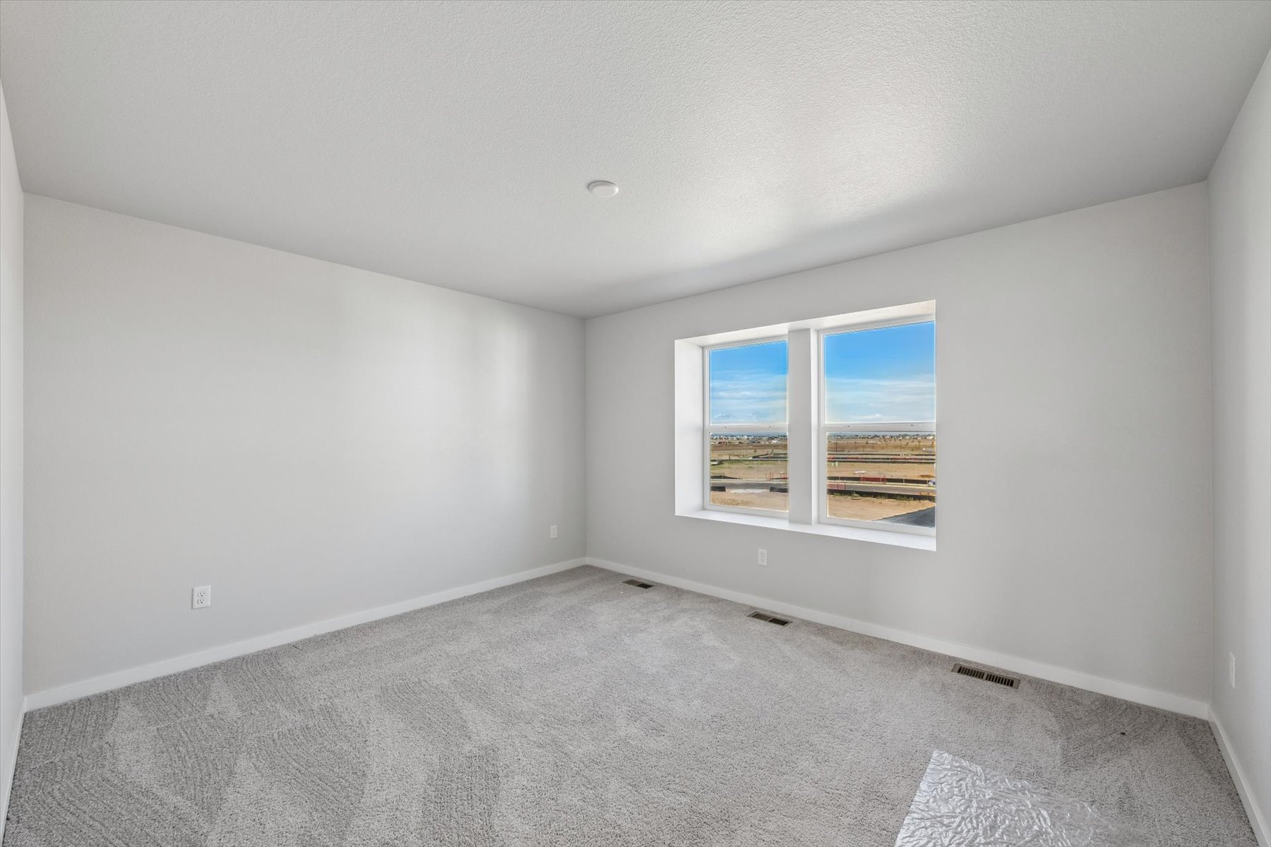 A room with a window and a carpet.