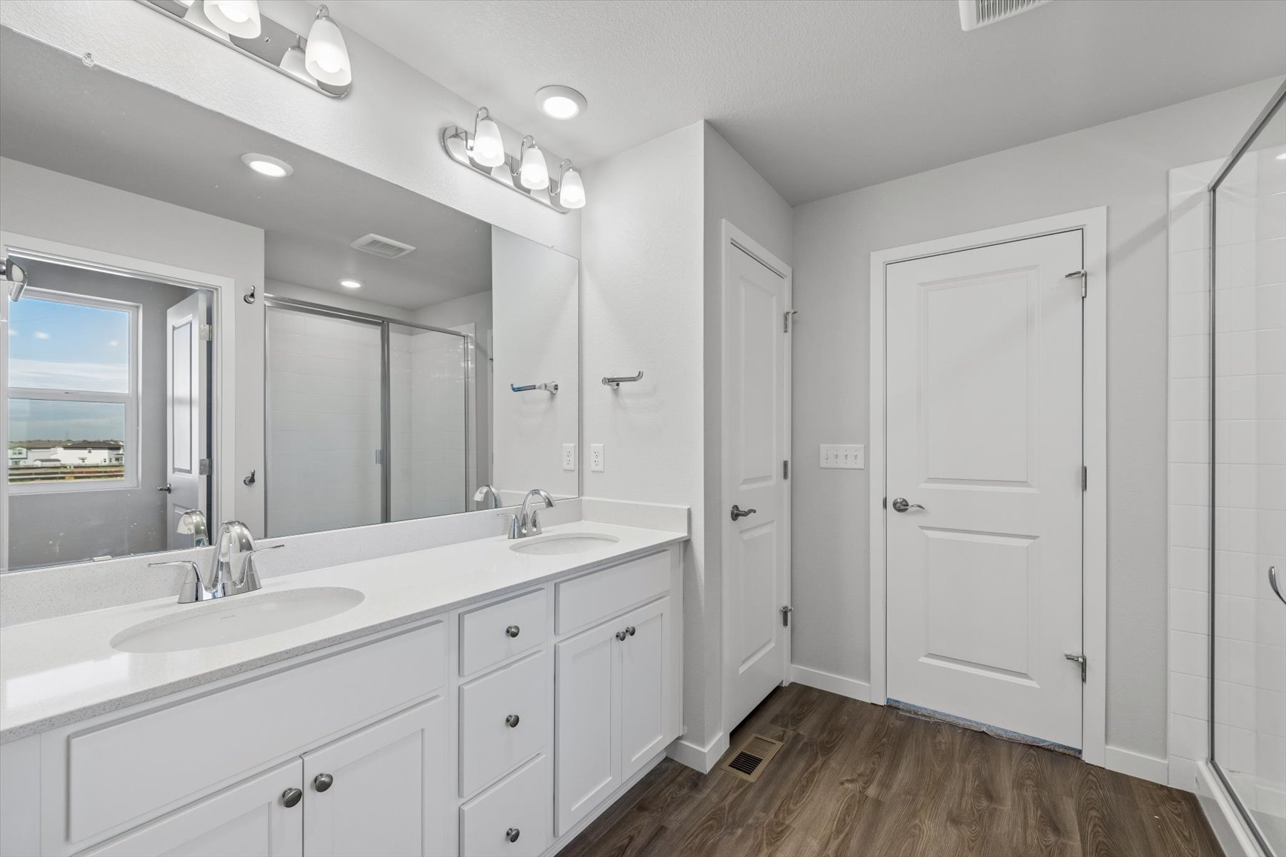 A bathroom with white cabinets.