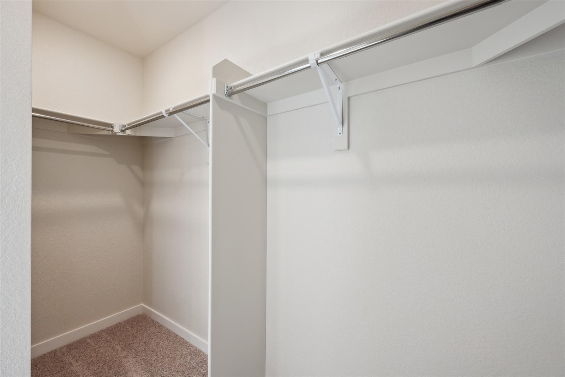 A white wall with a metal bar.