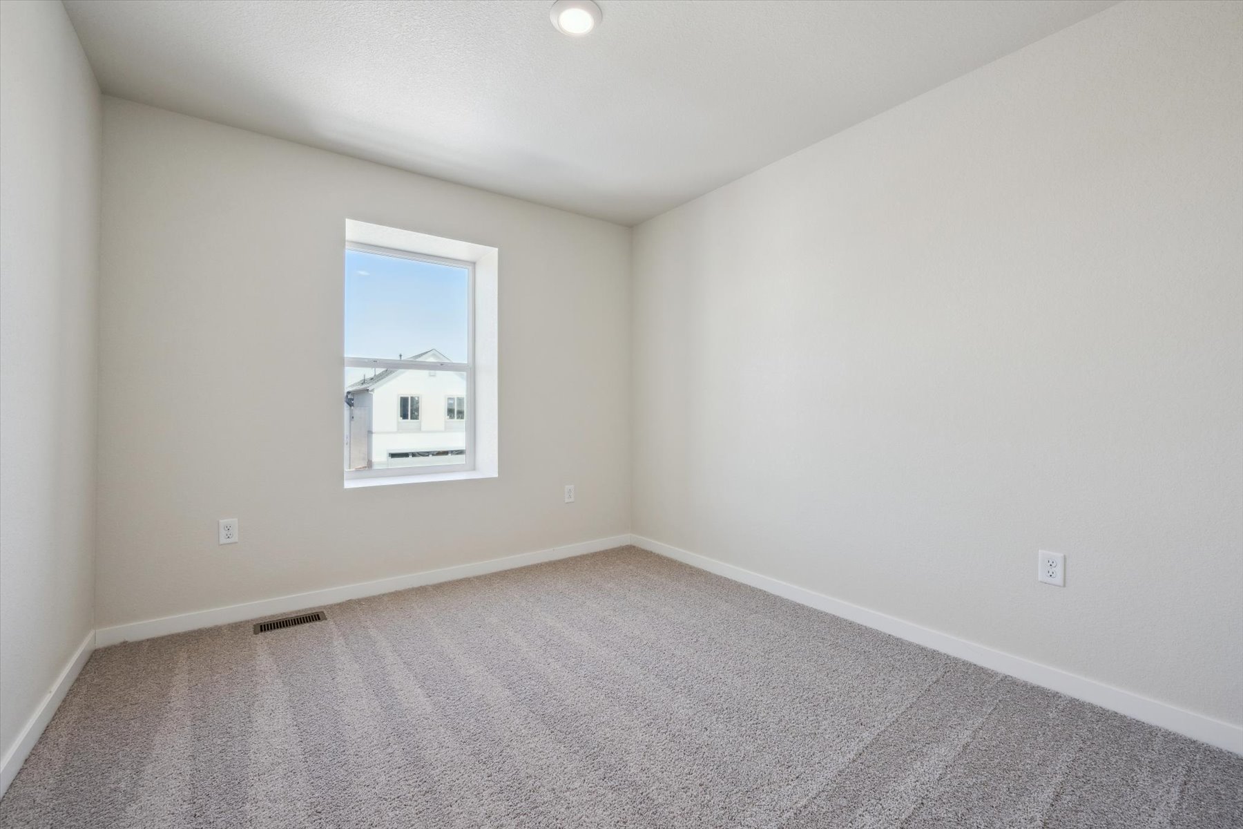 A room with a window and a carpet.