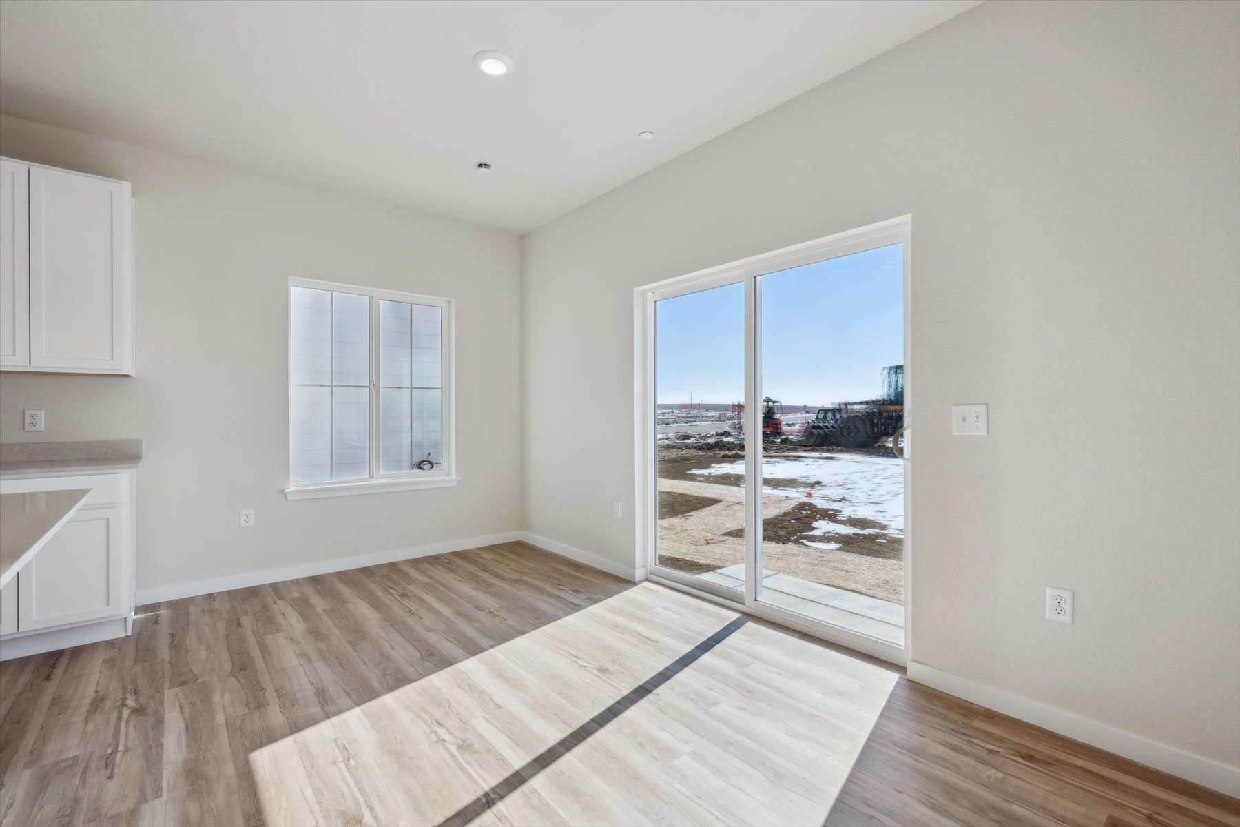 A room with a wood floor and a large window.