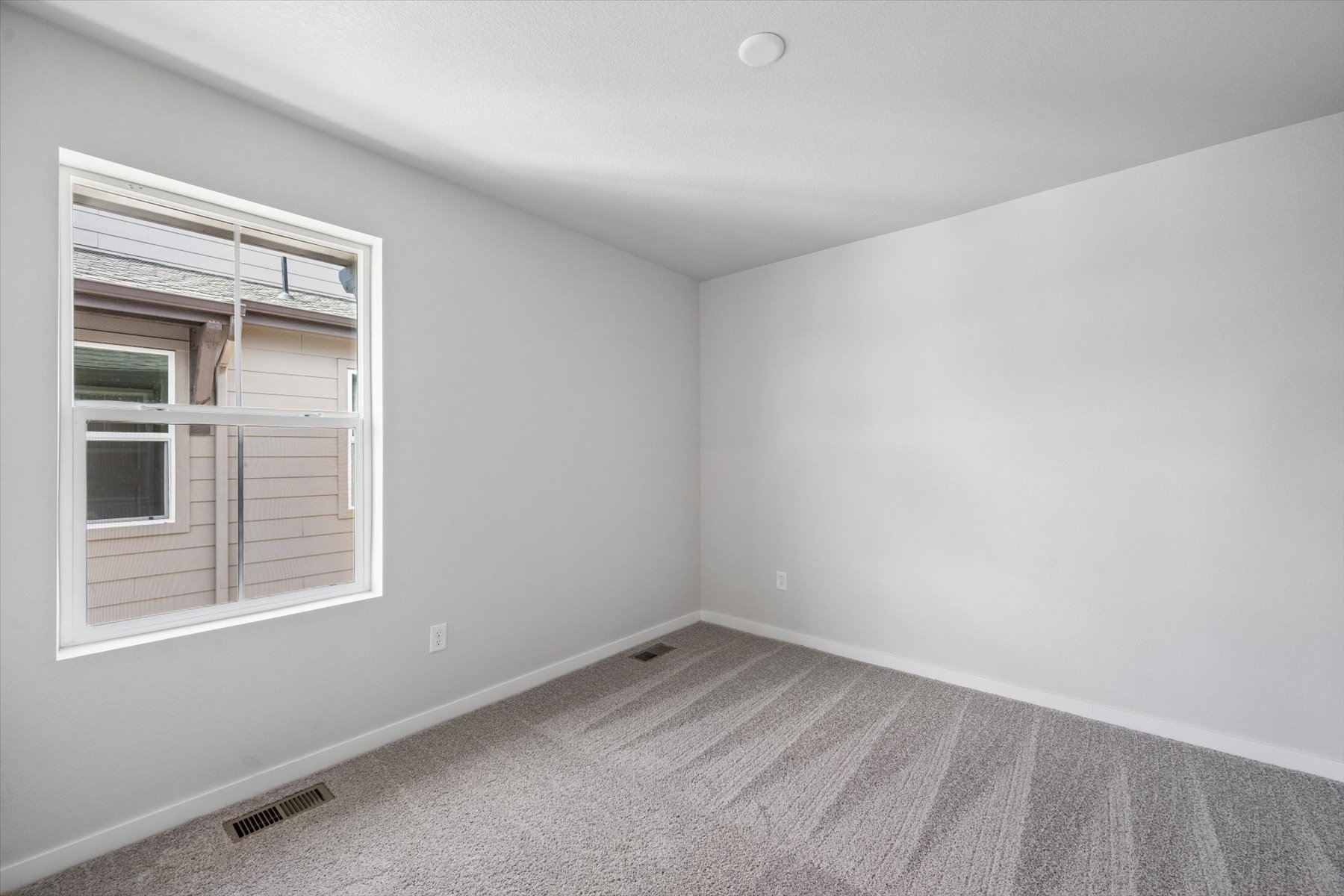 A room with a window and a rug.