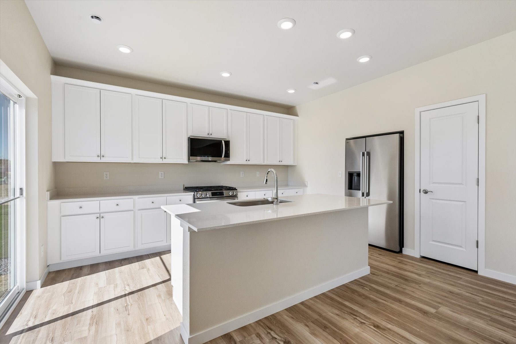 A kitchen with white cabinets.