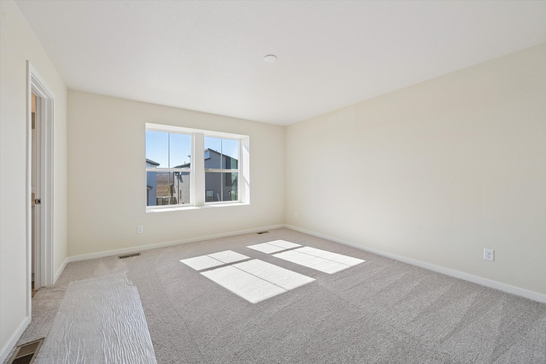 A room with a window and a rug.