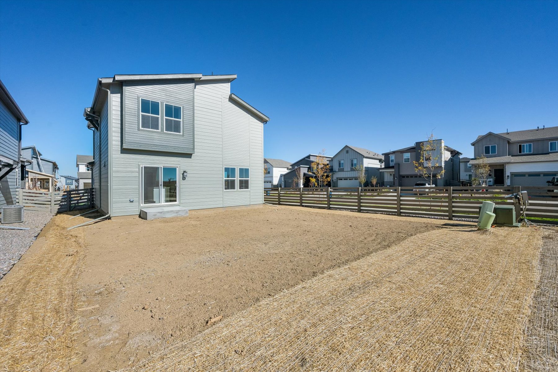 A dirt road with houses on the side.