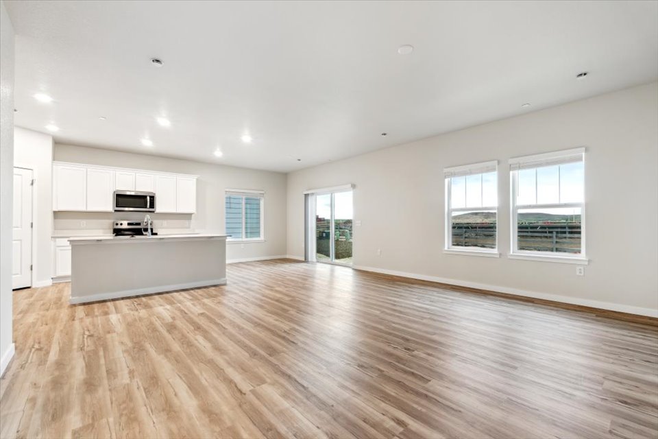 A large empty room with white cabinets.