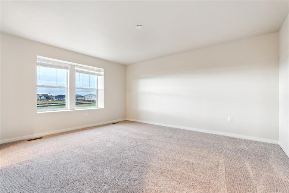 A room with a window and a carpet.