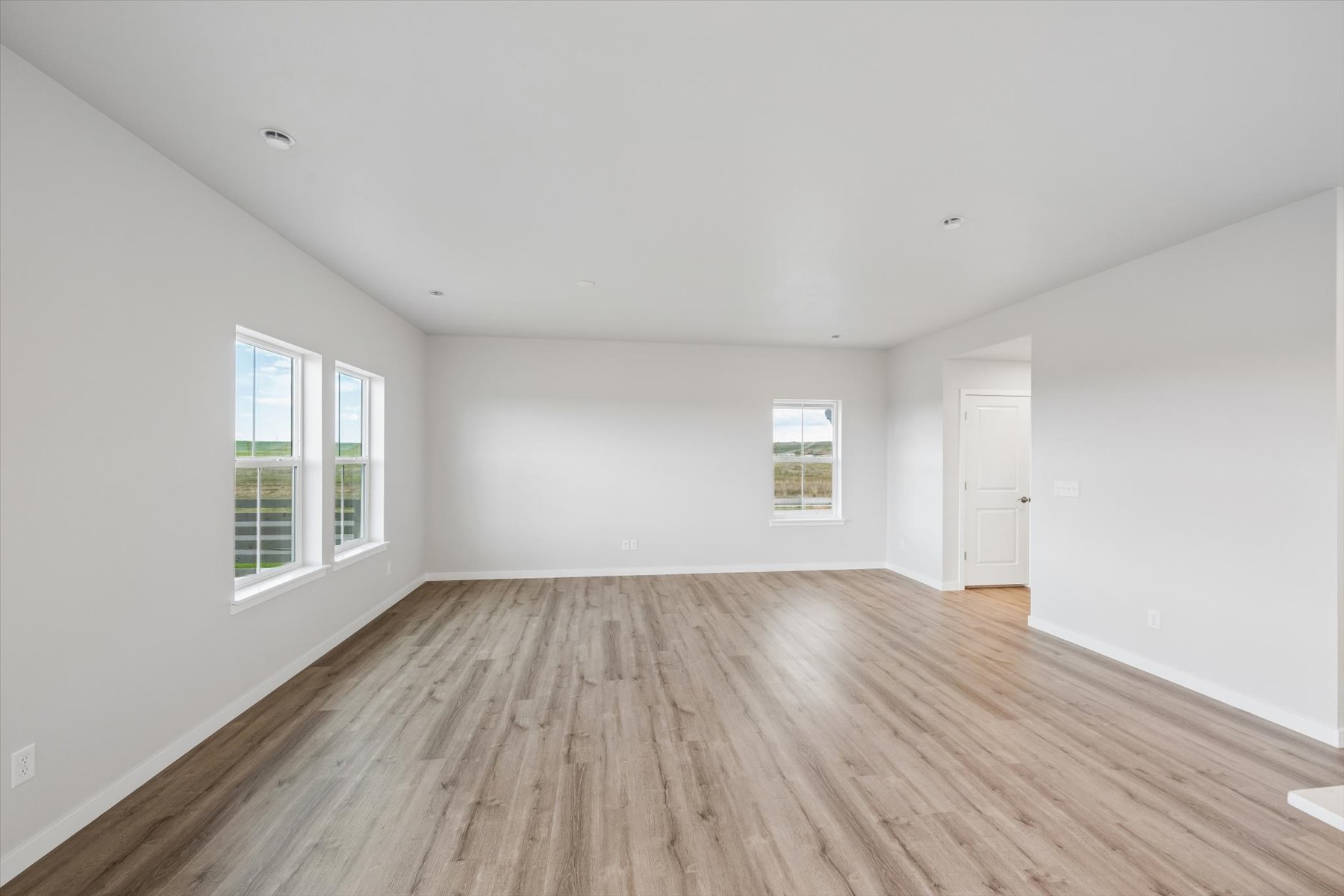 A room with a wood floor and windows.