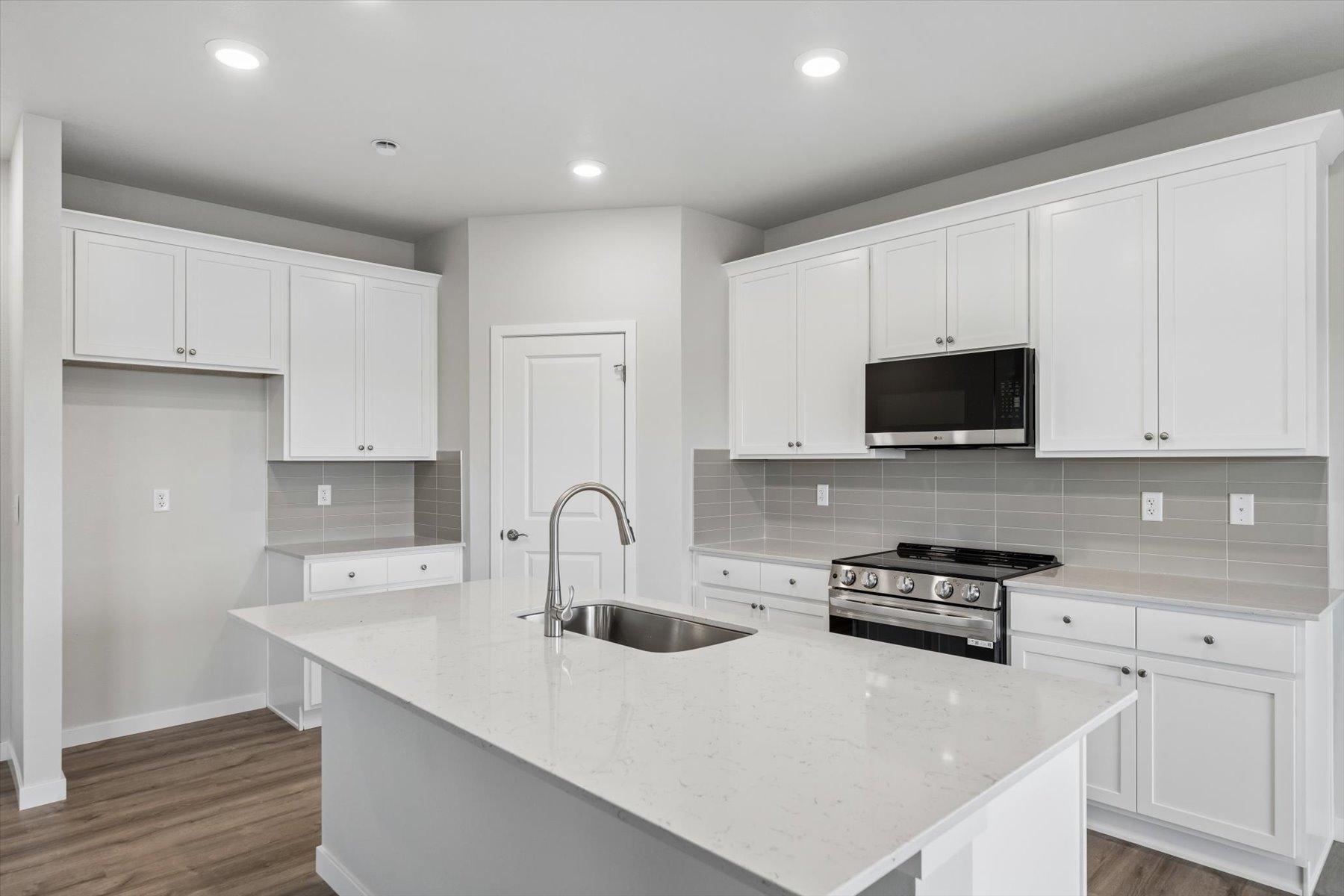A kitchen with white cabinets.