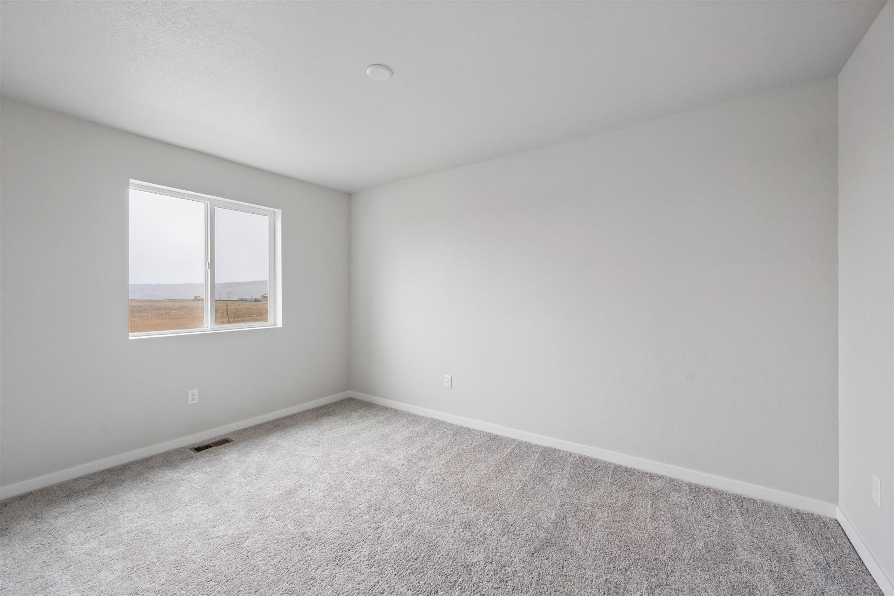 A room with a window and carpet.