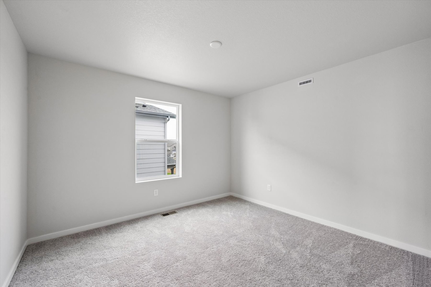 A room with a white wall and a window.