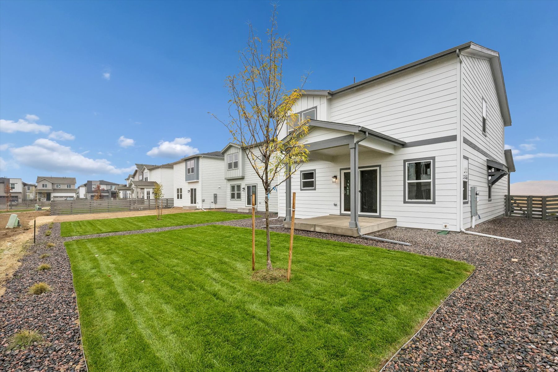 A house with a yard and a tree in front of it.
