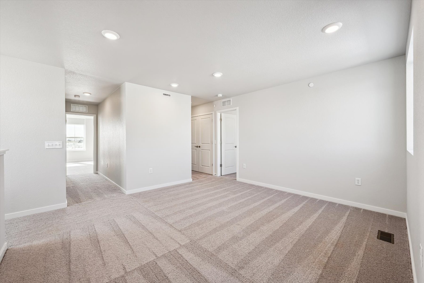 A long hallway with white doors.