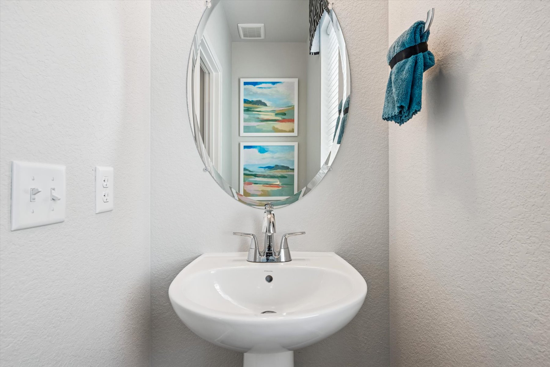 A bathroom with a mirror and a sink.
