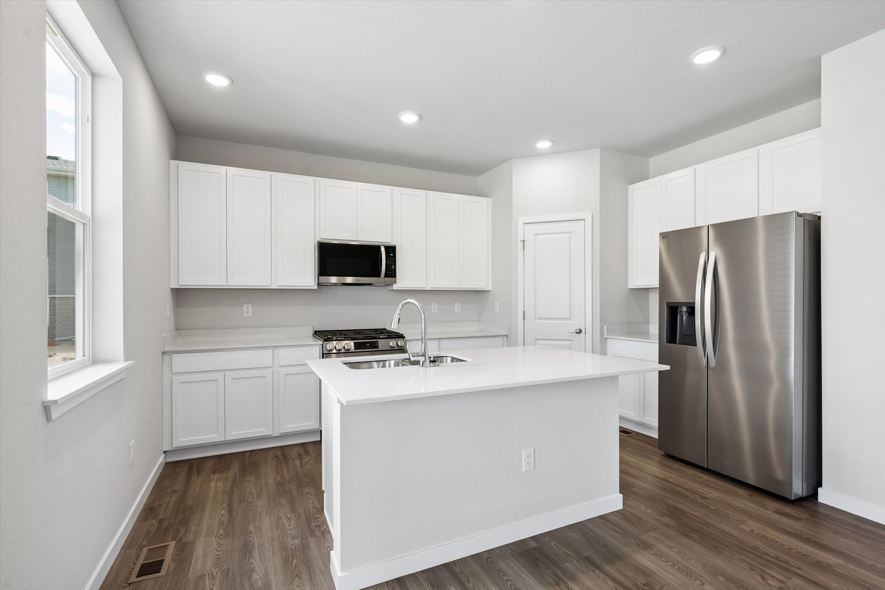 A kitchen with white cabinets.