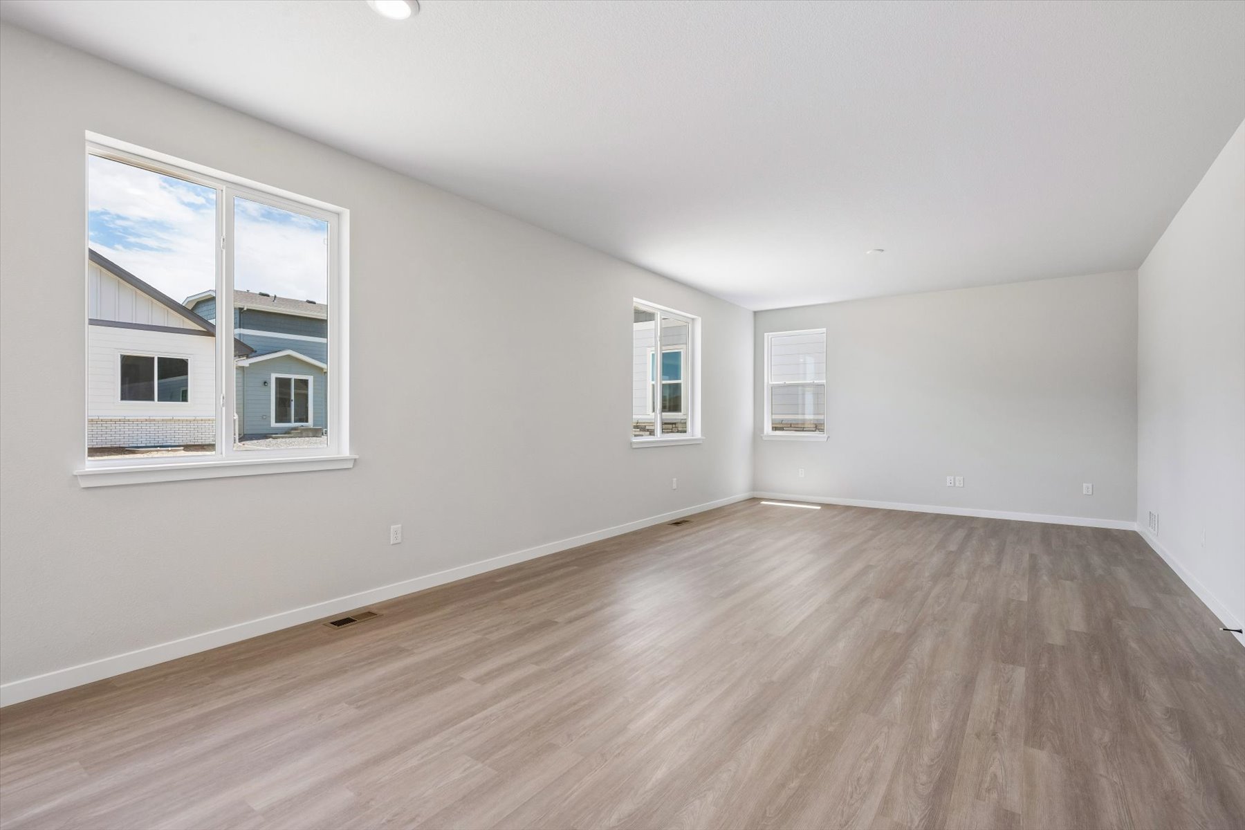 A room with a wood floor and windows.