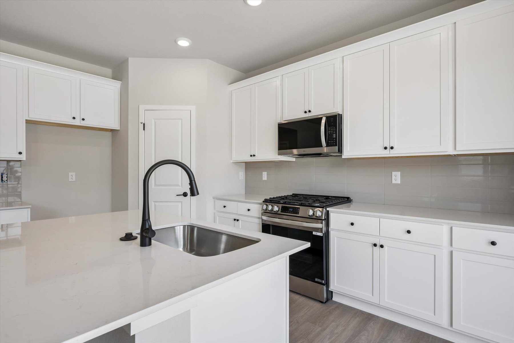 A kitchen with white cabinets.