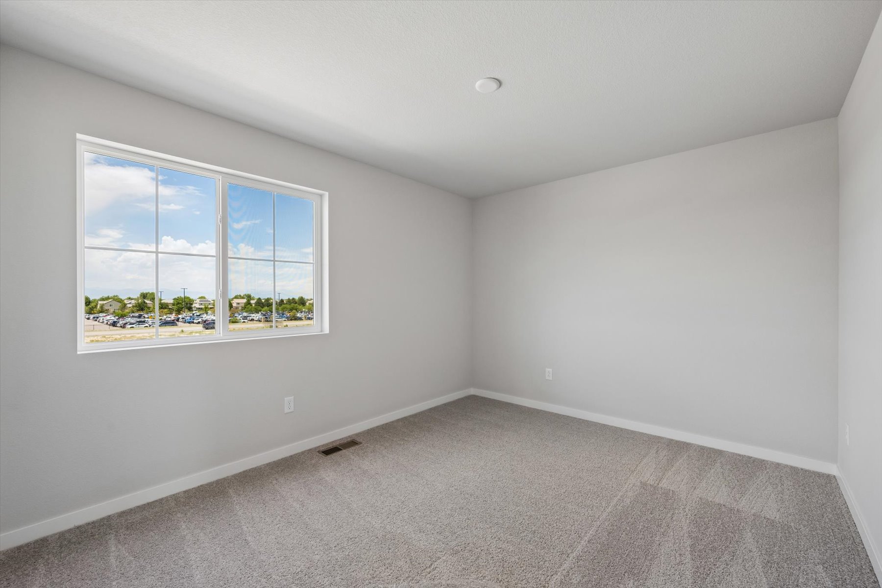A room with a window and a carpet.