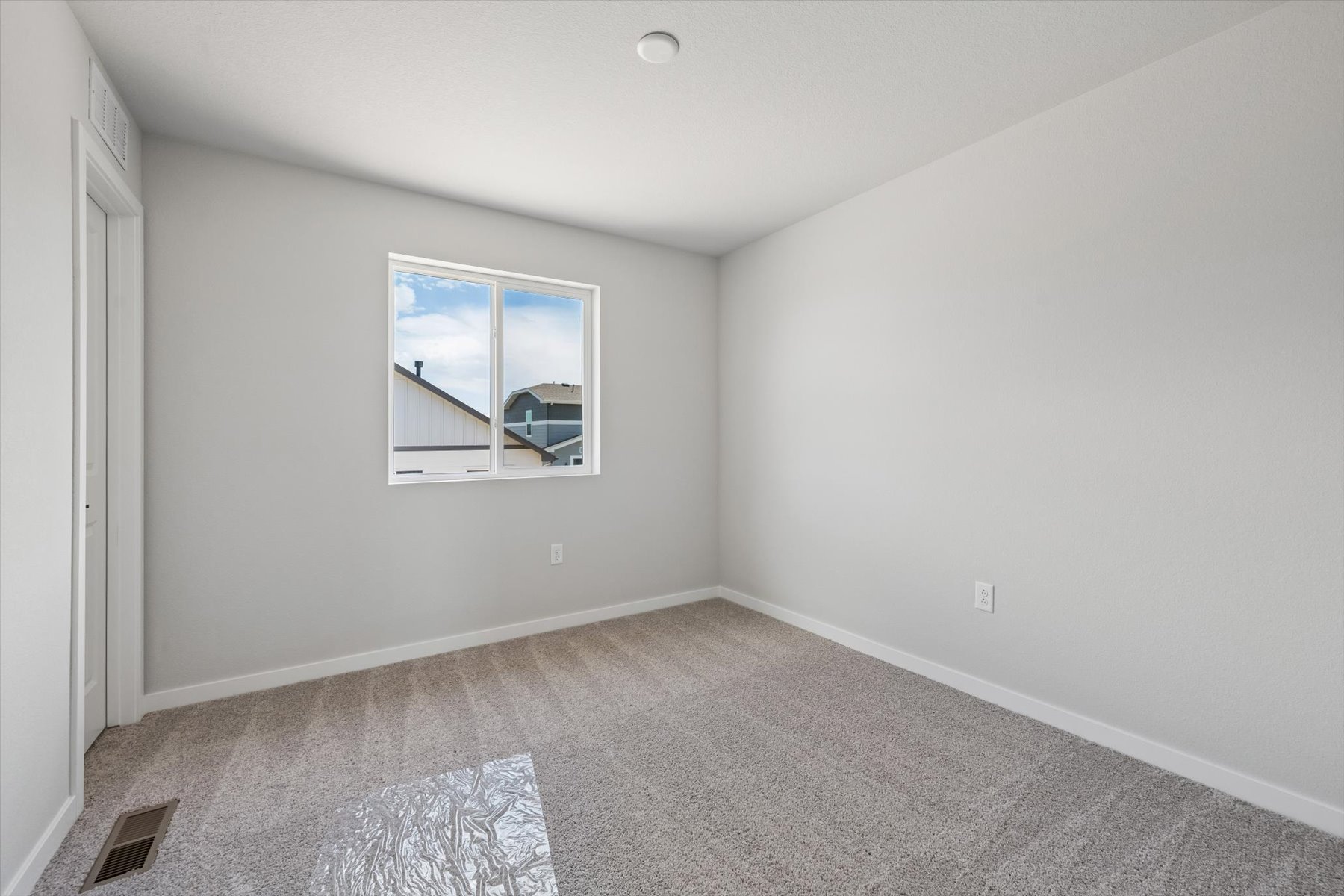 A room with a window and a rug.