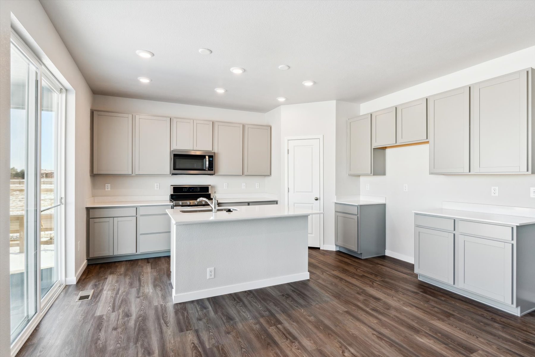 A kitchen with white cabinets.