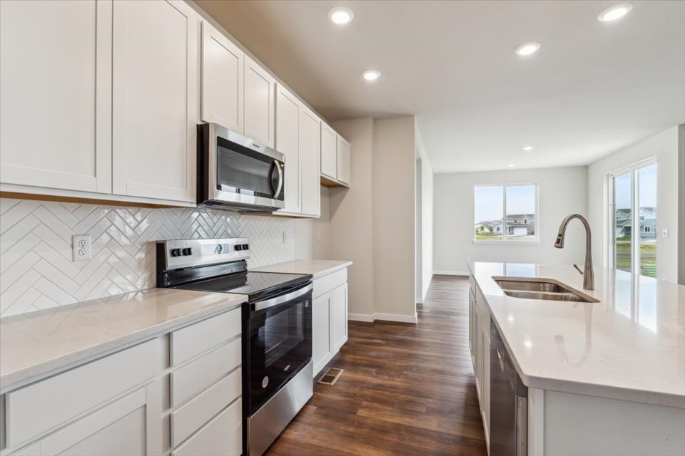 A kitchen with white cabinets.
