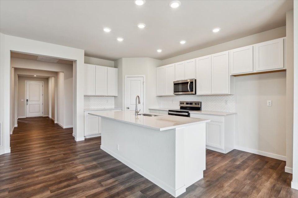 A kitchen with white cabinets.