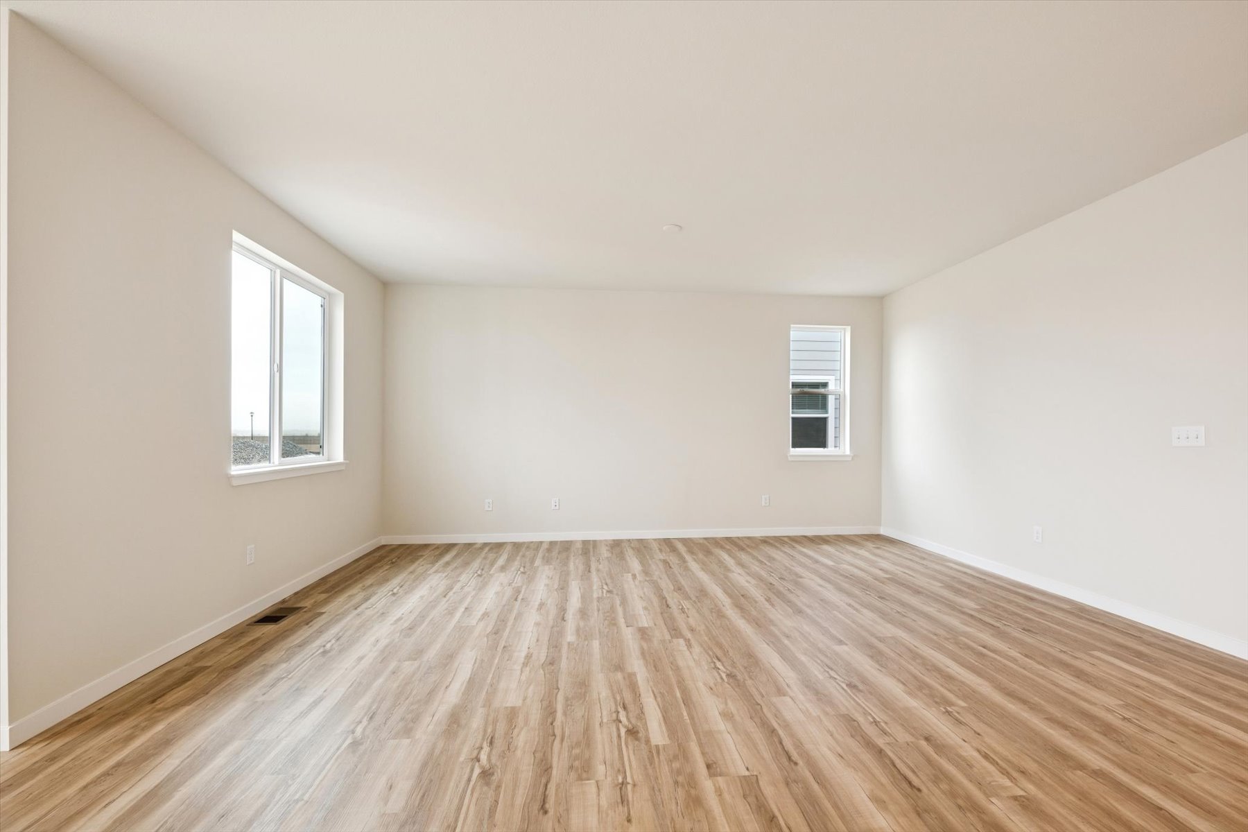 A room with a wood floor and windows.