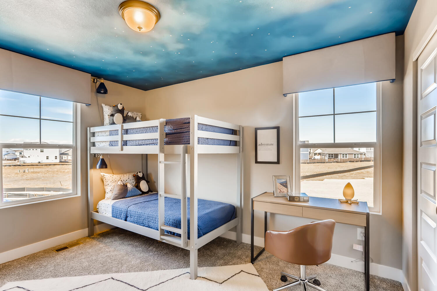 A bedroom with a bed desk and a chair.