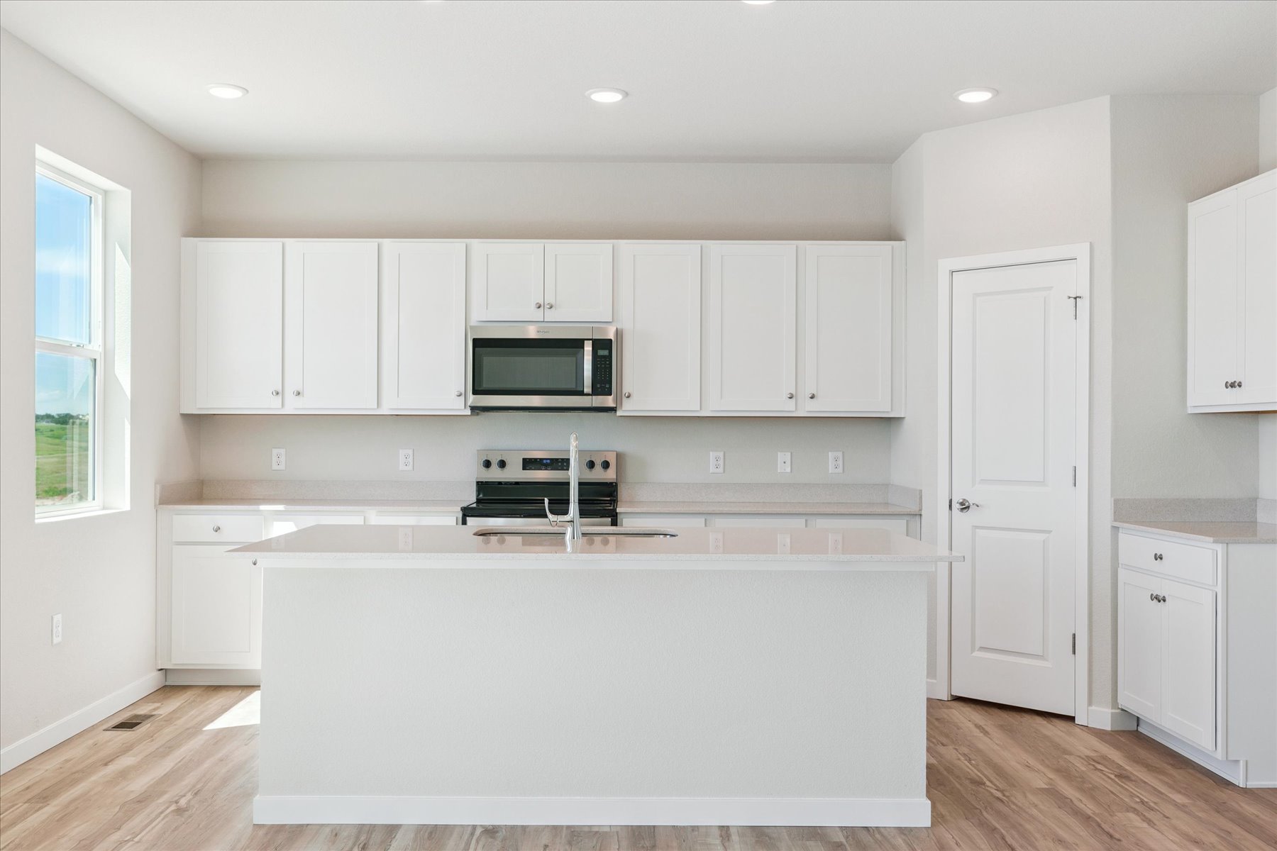 A kitchen with white cabinets.