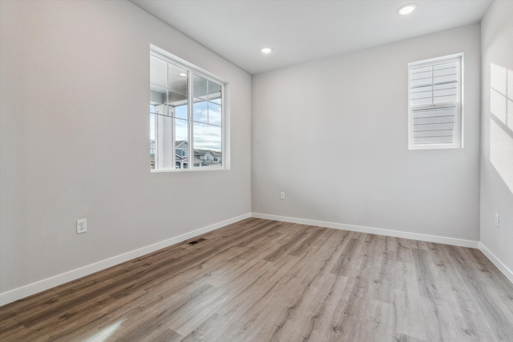 A room with a wood floor and a window.