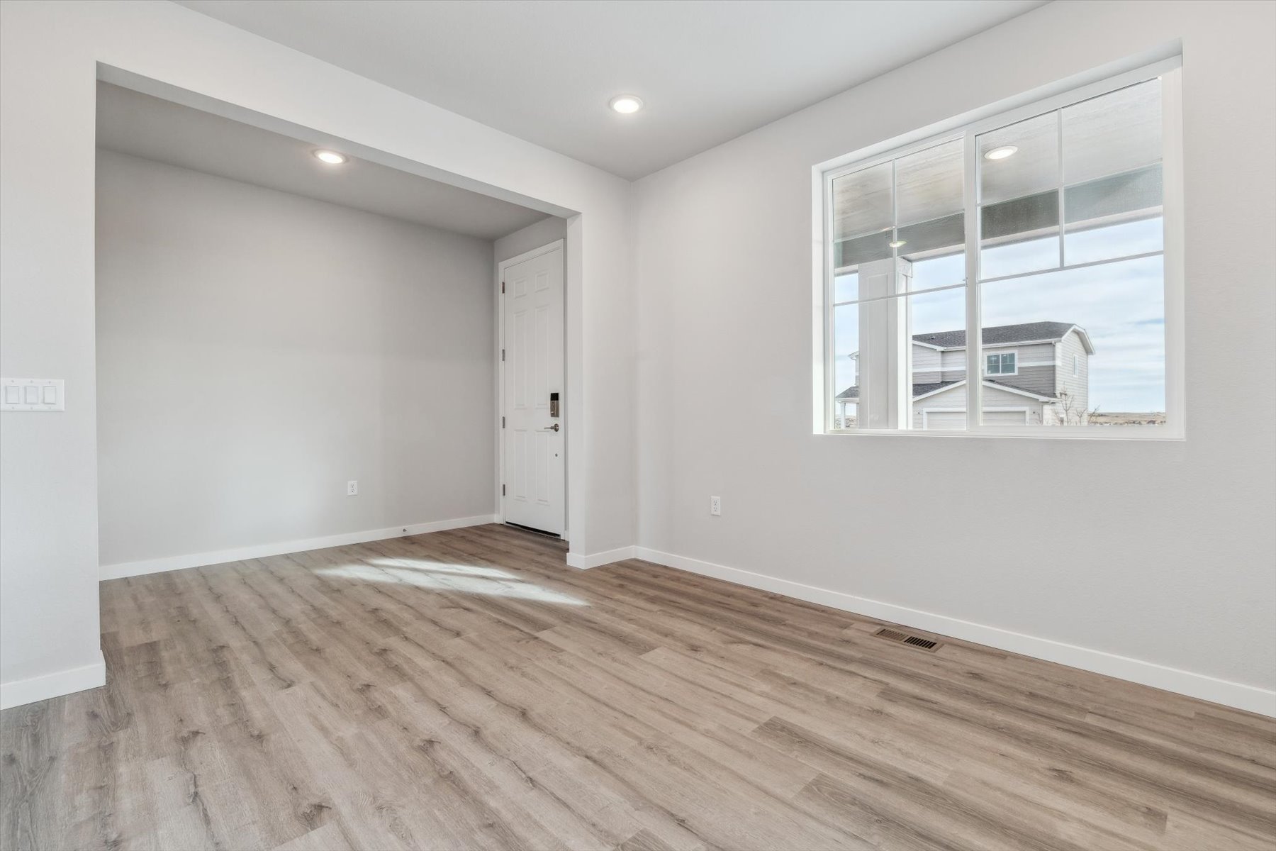A room with a wood floor and a window.