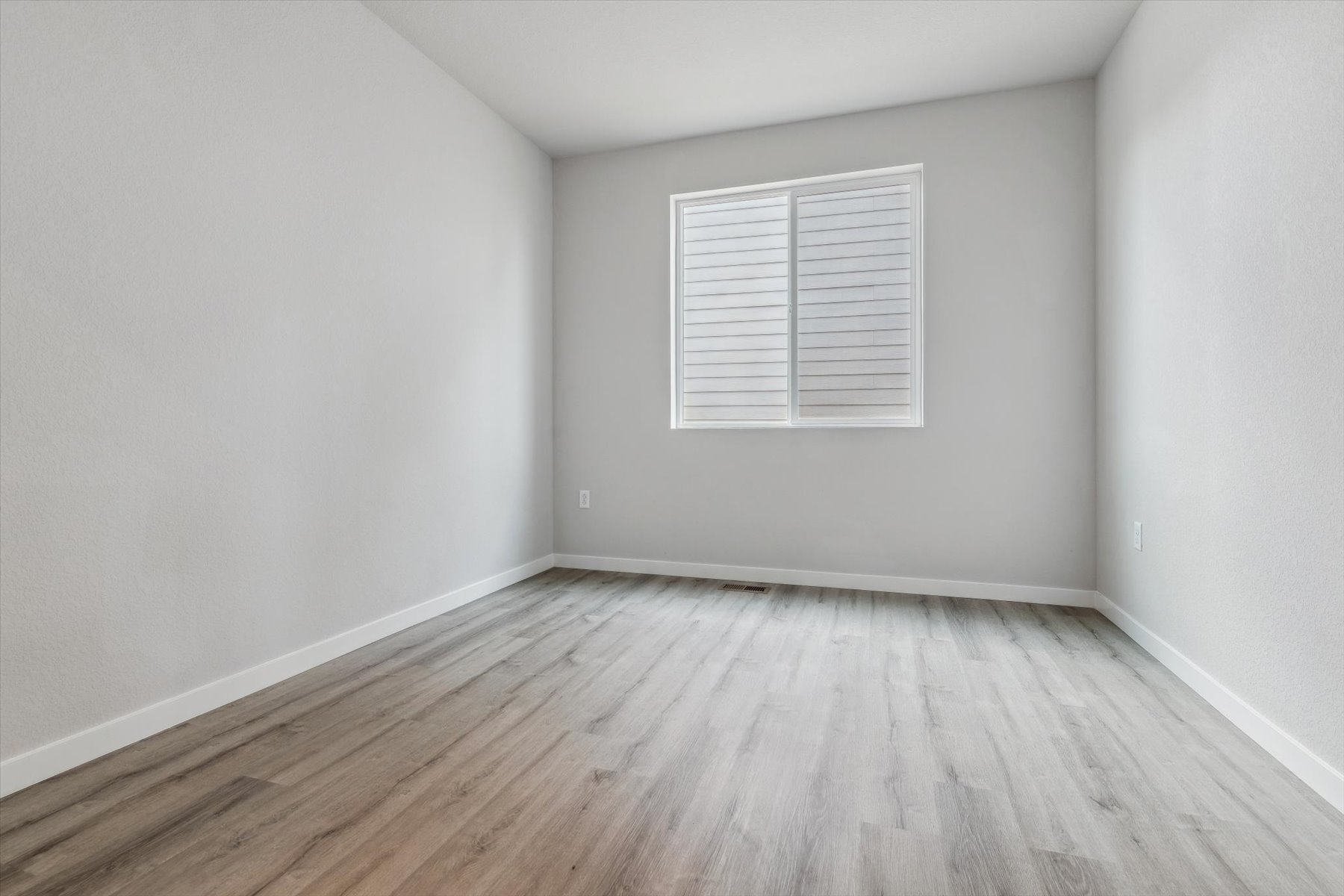 A room with a wood floor and white walls.