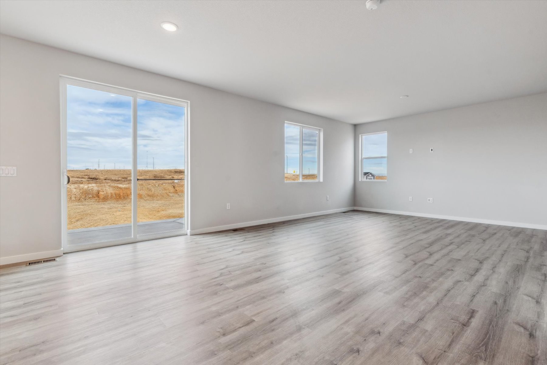 A room with a wood floor and windows.