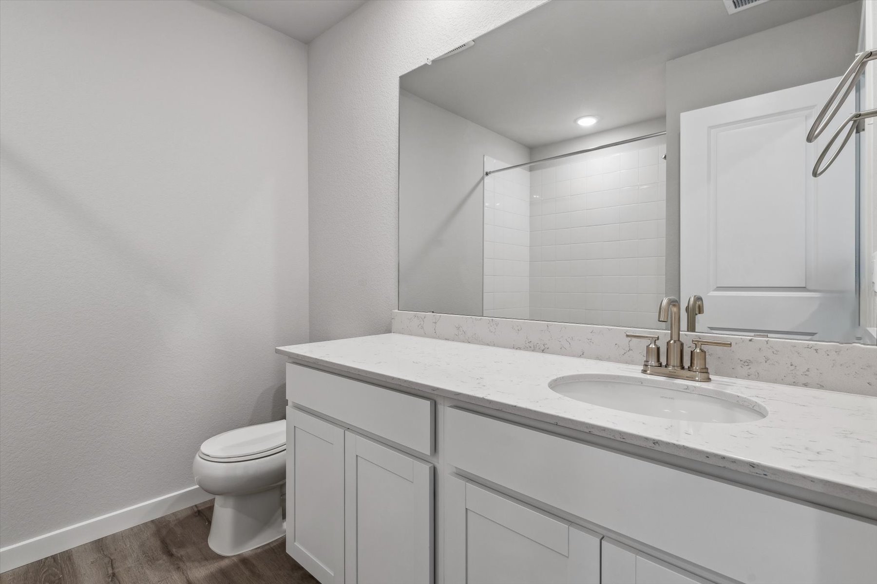 A bathroom with a large mirror.