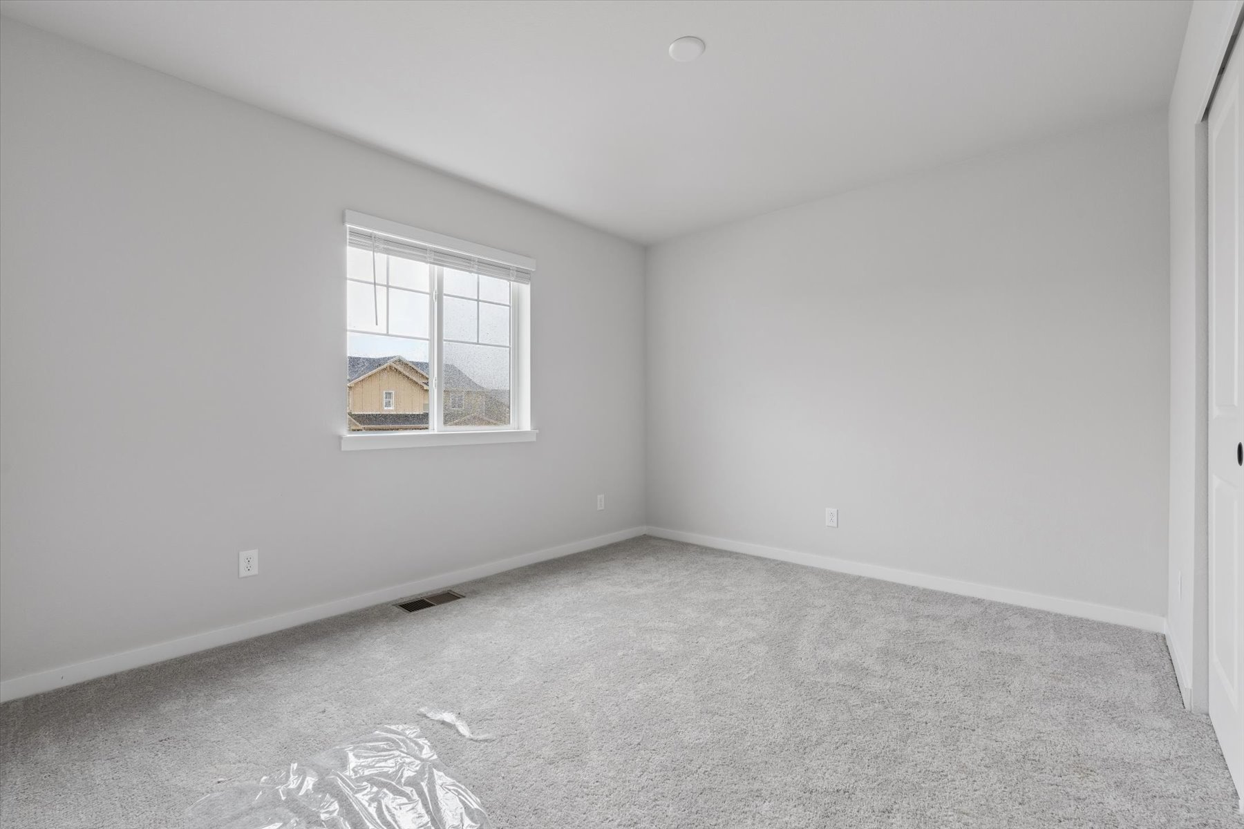 A room with a window and carpet.