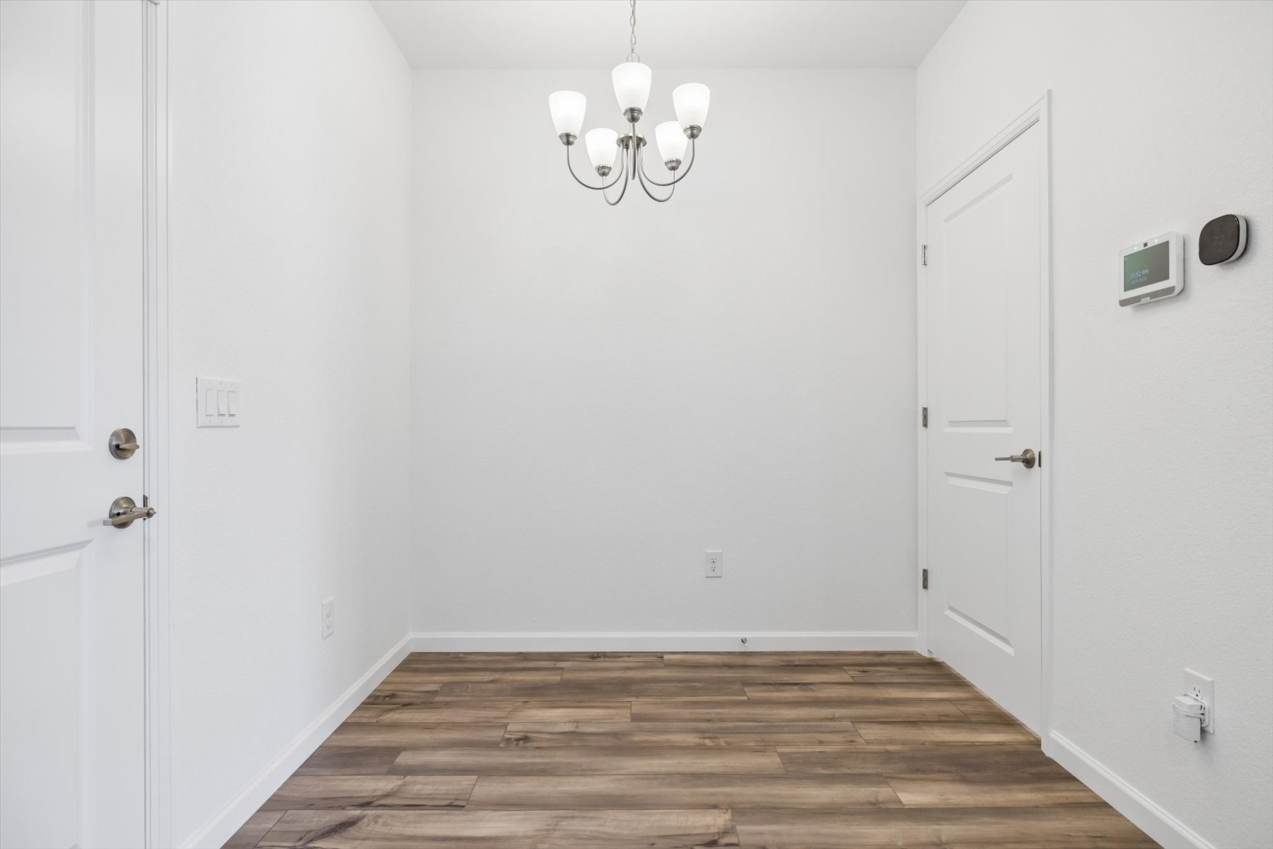 A room with white doors and a wood floor.