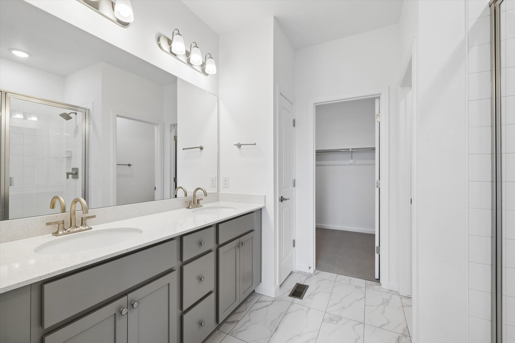 A bathroom with a sink and a shower unit.