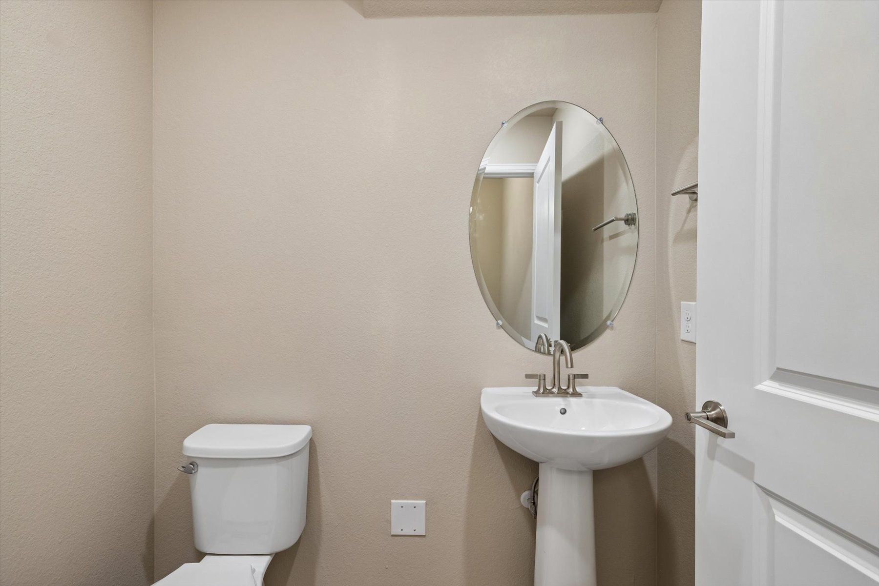 A bathroom with a round mirror.