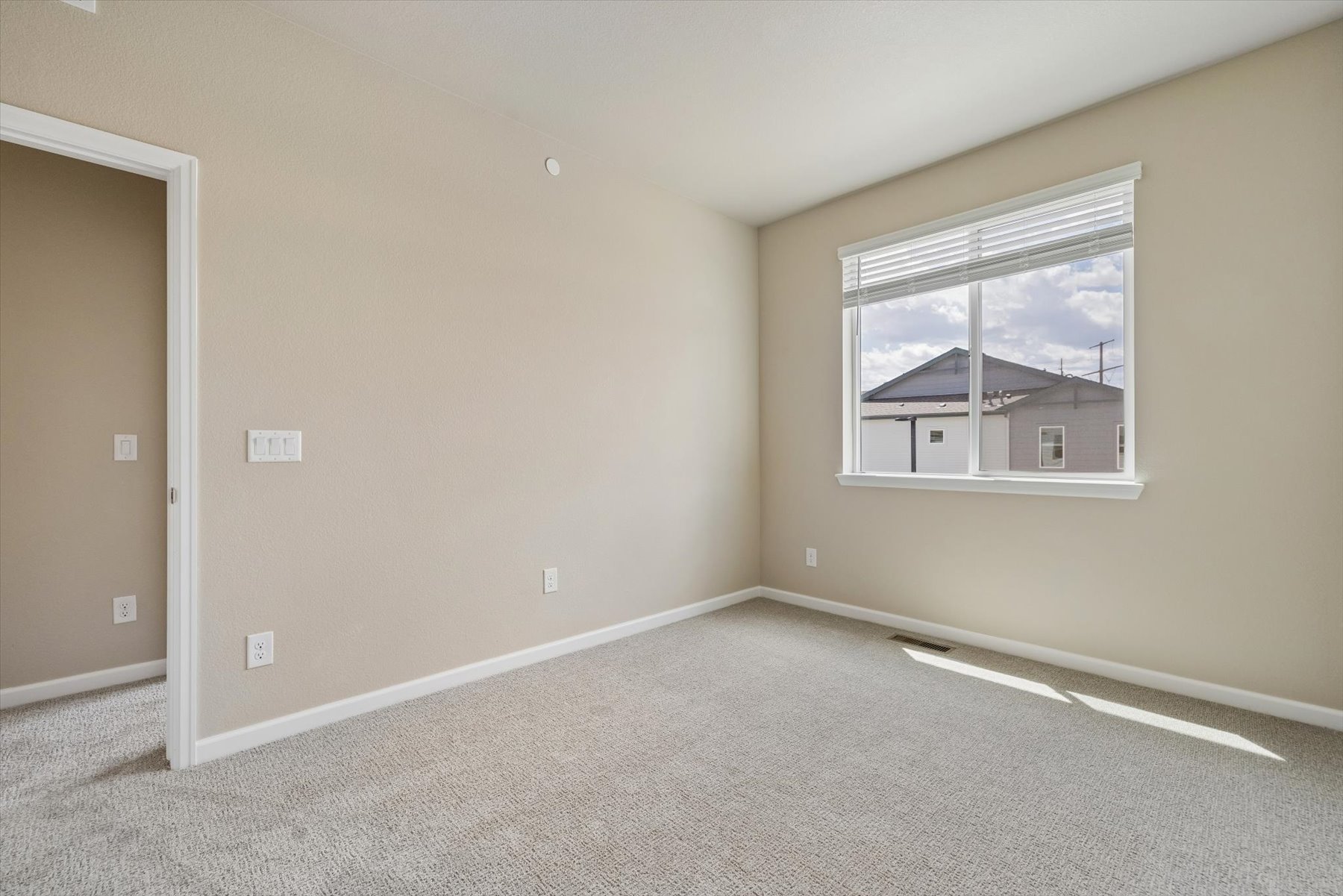 A room with a window and a carpet.